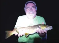  ?? OTIE MCKINLEY/FOR THE SUN-TIMES ?? Dale Bowman with a fish of a lifetime, a 23-inch brown trout pulled from the Au Sable River.