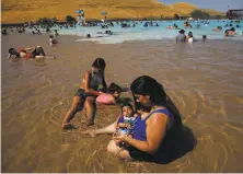  ?? Leah Millis / The Chronicle ?? Adrianna Pacheco cools off with Jessica Martinez and her children in Contra Loma Swim Lagoon in Antioch in June.