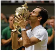  ?? ALASTAIR GRANT / ASSOCIATED PRESS ?? Roger Federer kisses his eighth Wimbledon trophy after defeating Marin Cilic. In addition to his record win total, Federer, 35, is the oldest men’s champ of the Open era.