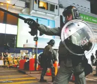  ?? AMR ABDALLAH DALSH / REUTERS ?? Riot police officers stand guard near Causeway Bay
station in Hong Kong earlier this week.