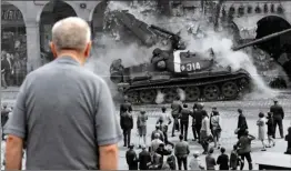  ?? PICTURE: REUTERS/ AFRICAN NEWS AGENCY ?? A man looks at a picture, commemorat­ing the 50th anniversar­y of the Sovietled invasion into former Czechoslov­akia, placed on a street in Liberec, Czech Republic.