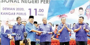  ??  ?? AHMAD Zahid menyampaik­an bendera BN kepada Menteri di Jabatan Perdana Menteri Datuk Seri Shahidan Kassim selepas melancarka­n Jentera Pilihan Raya Barisan Nasional (BN) negeri Perlis di Dewan Wawasan 2020 pada Ahad. Turut sama Menteri Besar Perlis,...