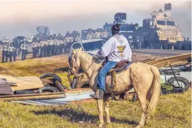  ??  ?? COURTESY OF THE MONROE GALLERY
“Defend the Sacred, Standing Rock Cannonball, North Dakota, 2016,” by Ryan Vizzions.