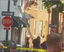  ??  ?? First responders and area residents gather at the scene of an electrical fire at a building in the 200 block of West Gay Street in West Chester Wednesday afternoon.