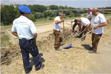  ?? — AFP photos ?? (Left) Inmates of the Rebibbia prison work under supervisio­n. • (Right) Inmates of the Rebibbia prison, work using garden tools, sharp implements, shears and trimmers, under the supervisio­n of the prison guard, as part of a gardening project by Tiber...