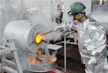  ?? JAY DIRECTO/Getty Images ?? A Filipino mill worker of Canadian miner TVI Pacific wearing a heat protection suit, pour a molten mixture of gold and silver
bullion mould at the end of the production line at its mine site at Canatuan mountain in the southern Philippine­s.