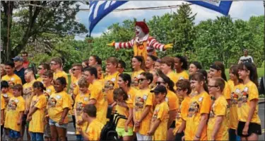  ?? PHOTOS BY MARIAN DENNIS – DIGITAL FIRST MEDIA ?? Racers stand at the finish line with Ronald McDonald before beginning a day of racing down Wilson Street for the annual Soap Box Derby Challenge race.