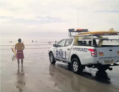  ??  ?? RNLI lifeguards on duty at Rest Bay, Porthcawl, where an elderly woman had to be rescued from the sea