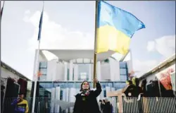  ?? (AP) ?? A woman waves a Ukrainian flag as she attends a protest against the war in Ukraine in front of the chanceller­y in Berlin, Germany, Oct. 11, 2022. German Chancellor Olaf Scholz hosts a meeting of the G7 leaders with Ukrainian President Volodymyr Zelenskyy on the situation in Ukraine.