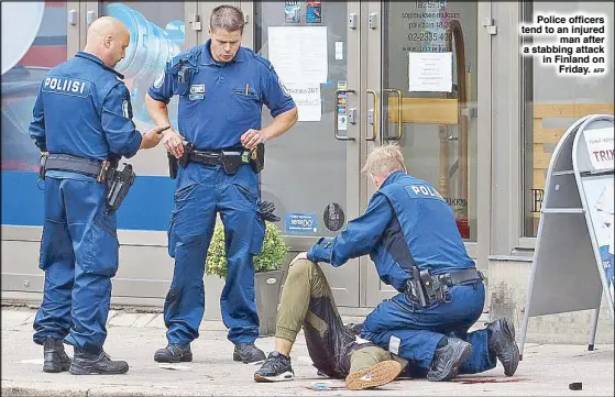  ?? AFP ?? Police officers tend to an injured man after a stabbing attack in Finland on Friday.