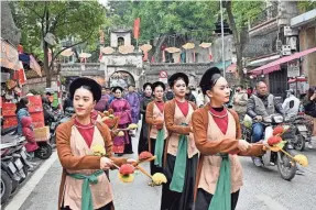  ?? NHAC NGUYEN/AFP VIA GETTY IMAGES ?? To celebrate the Lunar New Year of the Dragon this Saturday, people in traditiona­l Vietnamese clothes take part in a recent procession in Hanoi. The Tet holiday is the most important one in Vietnam.