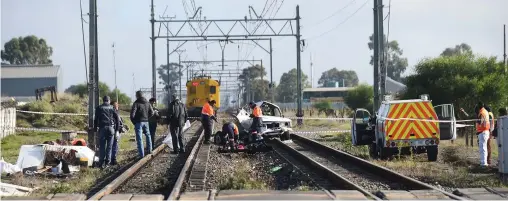  ?? PICTURE: PHANDO JIKELO/AFRICAN NEWS AGENCY (ANA) ?? DEADLY: Police and medical staff attend to an accident scene after seven people were killed when a train collided with a bakkie at the Buttskop level crossing near Kuils River. This is the same level crossing where 10 kids died when Jacob Humphreys...