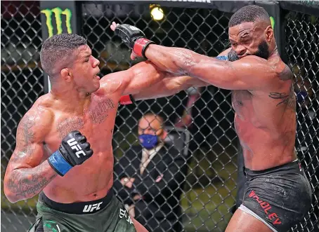  ?? Files/ Reuters ?? Gilbert Burns , left, during his fight against Tyron Woodley. Burns and Kamaru Usman will face off in the UFC 251 headline match in Abu Dhabi.