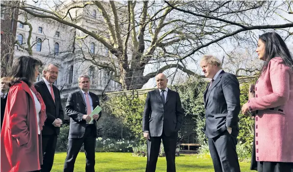  ??  ?? Prime Minister Boris Johnson and the five MPs and peers discuss the China bans in the Downing Street garden yesterday. It is the first time British parliament­arians have been formally sanctioned by a nation state