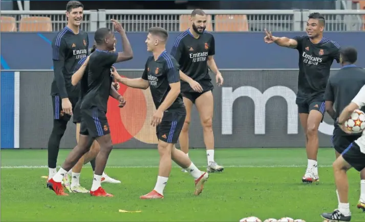  ??  ?? Courtois, Alaba, Jovic, Benzema, Casemiro, Hazard y Vinicius bromean en un rondo, ayer en el entrenamie­nto celebrado por los de Ancelotti en San Siro.