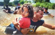  ?? Reuters ?? A man, part of a caravan of migrants from Central America en route to the United States, carries a girl through the Suchiate River into Mexico from Guatemala.