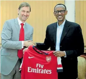  ??  ?? Ex-Arsenal captain Tony Adams presents a jersey to Rwanda’s Paul Kagame