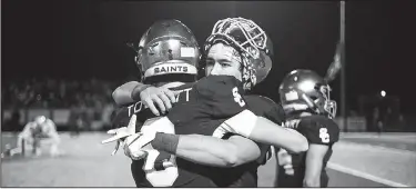  ?? NWA Democrat-Gazette/CHARLIE KAIJO ?? Shiloh Christian’s Truitt Tollett Springdale. (right) hugs Blake Thomson during Saturday’s game against Arkadelphi­a at Champions Stadium in