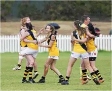  ??  ?? Toowoomba Tigers players embrace after the full-time siren sounds during their AFL Darling Downs women’s grand final. It marks the Tigers fourth flag in a row for the most successful team in women’s history.