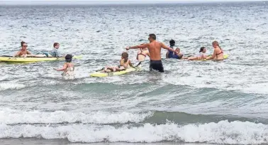  ?? DEB CRAM/SEACOASTON­LINE ?? Lifeguards at Hampton Beach give young swimmers a chance to ride on safety boards as part of Water Safety Day July 27.