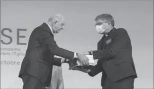  ?? -AP ?? PARIS
Commission president Jean-Marc Sauve, left, hands copies of the report to Catholic Bishop Eric de Moulins-Beaufort, president of the Bishops' Conference of France (CEF), during the publishing of a report by an independen­t commission into sexual abuse by church officials.