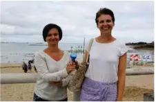  ??  ?? Delphine Briand et Béatrice Colleu avec le cendrier de plage frappé du slogan ’J’aime Lancieux’.