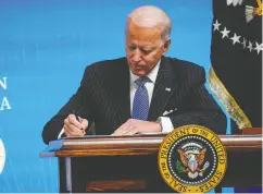  ?? Drew Angerer / GETTY IMAGES ?? U.S. President Joe Biden signs an executive order related to American manufactur­ing and Buy American in the
White House complex on Monday.