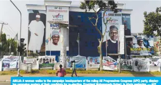  ??  ?? ABUJA: A woman walks to the campaign headquarte­rs of the ruling All Progressiv­es Congress (APC) party, displaying campaign posters of their candidate for re-election, President Mohammadu Buhari, in Abuja yesterday. — AFP