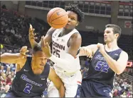  ?? Jim Michaud / Associated Press ?? UConn’s Josh Carlton loses the ball while being doubled-teamed by Southern Connecticu­t’s William Antrum (2) and Luke Beesley (52) Friday night in Storrs.