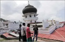  ?? The Associated Press ?? Men inspect a collapsed mosque after an earthquake Wednesday in Pidie Jaya, Aceh province, Indonesia.