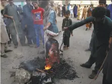  ?? Pervez Masih / Associated Press ?? Protesters burn a poster image of Christian woman Asia Bibi, who spent eight-years on death row accused of blasphemy.