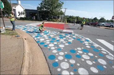  ?? NWA Democrat-Gazette/J.T. WAMPLER ?? Volunteers work Sunday at painting new crosswalk and curb extensions at the Church Avenue intersecti­on with Center Street. Fayettevil­le has officially launched its Tactical Urbanism program where residents can put together a plan to build a crosswalk...