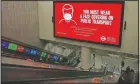  ??  ?? Customers ride the escalators at King’s Cross Undergroun­d station with a coronaviru­s informatio­n advertisem­ent on a large screen over the escalators.