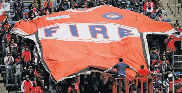  ?? JONATHAN DANIEL/GETTY IMAGES ?? Fans unfurl a large Fire jersey after the team scored during an MLS match against the Rapids at SeatGeek Stadium in April. The Fire have conducted two surveys about a potential name change.