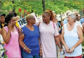  ?? MARIAN DENNIS — DIGITAL FIRST MEDIA ?? Attendees at the Pottstown vigil for Charlottes­ville embraced as the crowd sang a rendition of “We Shall Overcome.”