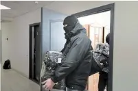  ?? THE ASSOCIATED PRESS ?? Police carry documents and computers out of the office of the Belarusian Associatio­n of Journalist­s in Minsk on Tuesday.