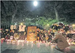  ??  ?? REMEMBRANC­E: A man lights a candle at a makeshift memorial near the Bataclan concert hall in Paris as France marked the first anniversar­y of the Paris attacks with sombre ceremonies in November 2016.