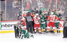  ?? PAUL BATTAGLIA/ASSOCIATED PRESS ?? Minnesota’s Jared Spurgeon, on knees, is attended to by referee Kyle Rehman after being speared in the face by Detroit’s Gustav Nyquist. At rear, Wild players look to get at Nyquist.