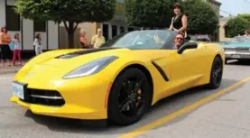  ??  ?? Peter Bleakney pilots a 2014 Stingray Z51 Convertibl­e in the town of Zurich’s 150th anniversar­y parade, near Grand Bend, Ont., with Aimee Rau, who was crowned Fair Queen back in 1991.
