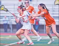  ?? David Stewart / Hearst Connecticu­t Media ?? New Canaan’s Kaleigh Harden (6) cuts between Ridgefield’s Amy Gagnon (18) and Faith Arnold (14) during the CIAC Class L girls lacrosse semifinals at Brien McMahon High School on Monday.