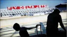  ?? DAVID GOLDMAN — THE ASSOCIATED PRESS FILE ?? Passengers unload in front of a Delta Air Lines sign at Hartsfield­Jackson Atlanta Internatio­nal Airport, in Atlanta. Georgia lawmakers punished Atlanta-based Delta Air Lines on Thursday for its decision to cut business ties with the National Rifle...