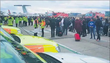  ??  ?? Airport staff in high-visibility jackets marshallin­g the crowds during the chemical alert emergency