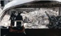  ??  ?? Women walk past damage near al-Quds hospital after it was hit by airstrikes, in a rebel-held area of Aleppo.