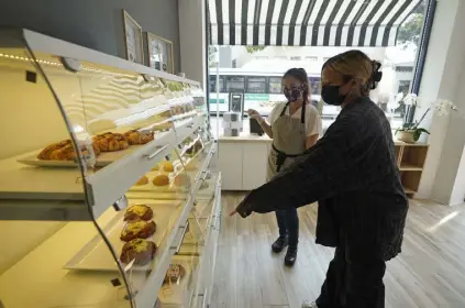  ?? Eric Risberg, The Associated Press ?? Pastry chef Elaine Lau, left, assists a customer at the Sunday Bakeshop in Oakland, Calif., in August.