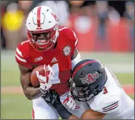  ?? AP/NATI HARNIK ?? Arkansas State defensive back B.J. Edmonds (right) brings down Nebraska wide receiver Tyjon Lindsey during the first half of Saturday night’s game at Lincoln, Neb.