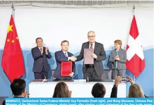  ?? ?? KEHRSATZ, Switzerlan­d: Swiss Federal Minister Guy Parmelin (front right), and Wang Shouwen, Chinese Vice Minister of the Ministry of Commerce, shake hands after signing a joint statement of the free trade agreeTLU[ K\YPUN HU VMÄJPHS ]PZP[ [V 2LOYZH[a VU 1HU ¶ (-7