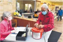  ??  ?? Linda Brown, right, of Chicago, chats with volunteer Sabina Reyes, of Crestwood, as she puts her donation for lunch in a Salvation Army red kettle last week at the Salvation Army Crossgener­ations Center in Blue Island. Brown joined the Senior Lunch program about a month ago when her husband became ill.