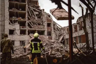  ?? Francisco Seco/Associated Press ?? Firefighte­rs work on a building that was partially destroyed after a Russian bombardmen­t in Chernihiv, Ukraine, on Wednesday.