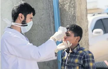  ?? REUTERS ?? A health worker tests an internally displaced Syrian boy as part of security measures to avoid coronaviru­s in Azaz, Syria on Tuesday.