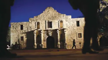  ?? Associated Press ?? In this March 6, 2013, file photo, Dan Phillips, a member of the San Antonio Living History Associatio­n, patrols the Alamo during a pre-dawn memorial ceremony to remember the 1836 Battle of the Alamo and those who fell on both sides in San Antonio....